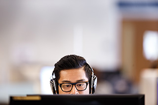 student wearing headphones at computer