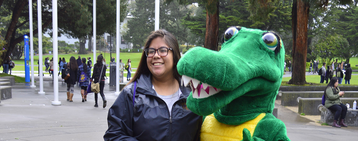 Student posing with SF State's Gator mascot